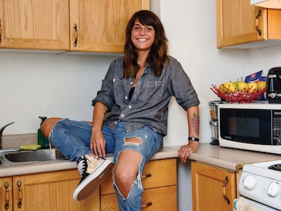 One of our co-founders sitting in their kitchen and smiling.
